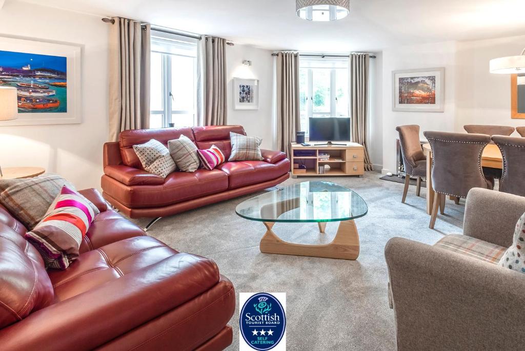 a living room with a leather couch and a glass table at The Malt Kiln Apartment Edinburgh Old Town 3 Bedroom Parking previously McDonald Residence in Edinburgh