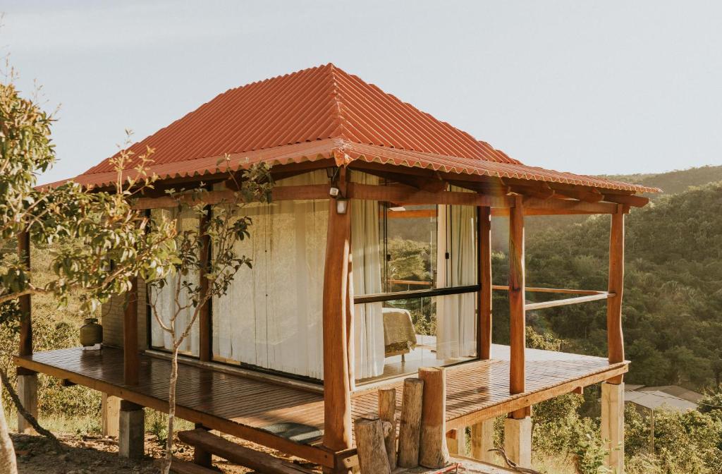 a house with a roof on a wooden deck at Chalé Brisas in Alto Paraíso de Goiás