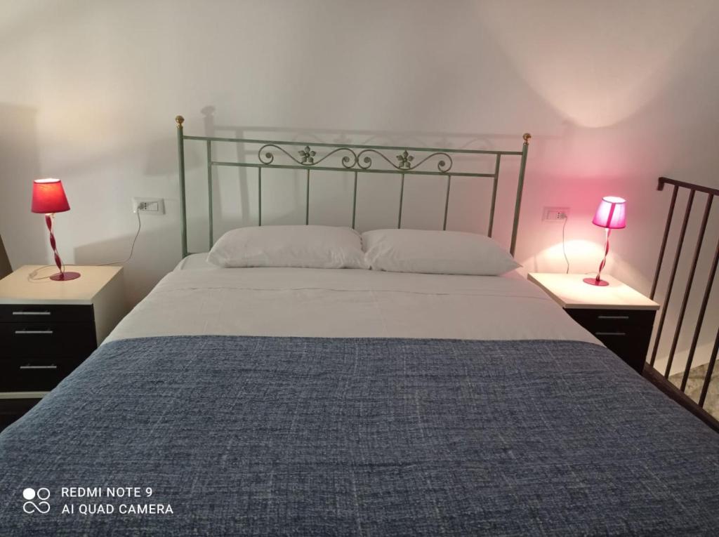 Casa Angelene في فيتورشيانو: غرفة نوم بسرير كبير مع وجود مصباحين على الطاولات