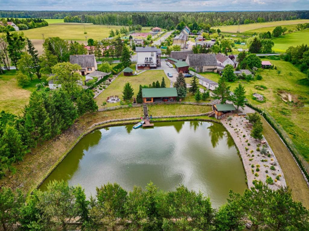 una vista aerea di una casa con un ponte sul lago di Kamienica House 9 a Wągrowiec