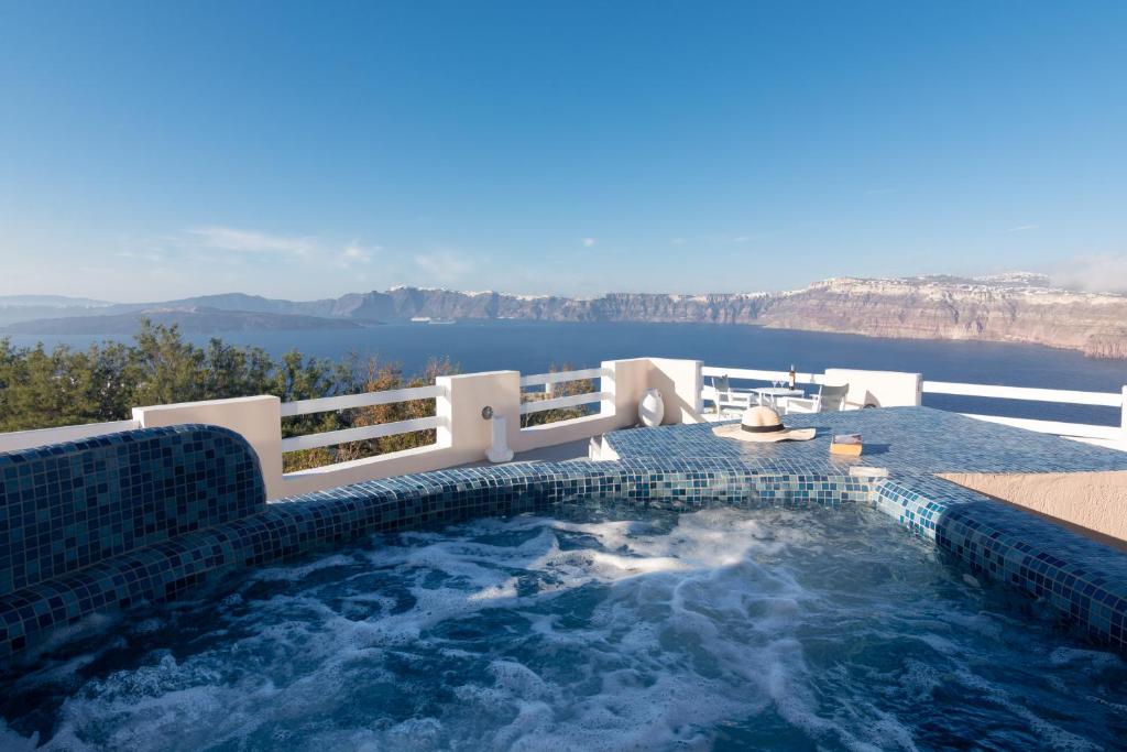 a hot tub with a view of the water at Akrotiri Apartments in Akrotiri