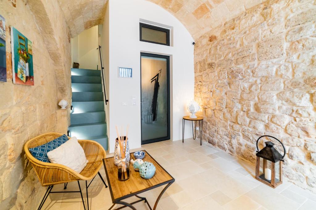 a living room with a table and chairs and a stone wall at B&B A C-Caste in Monopoli