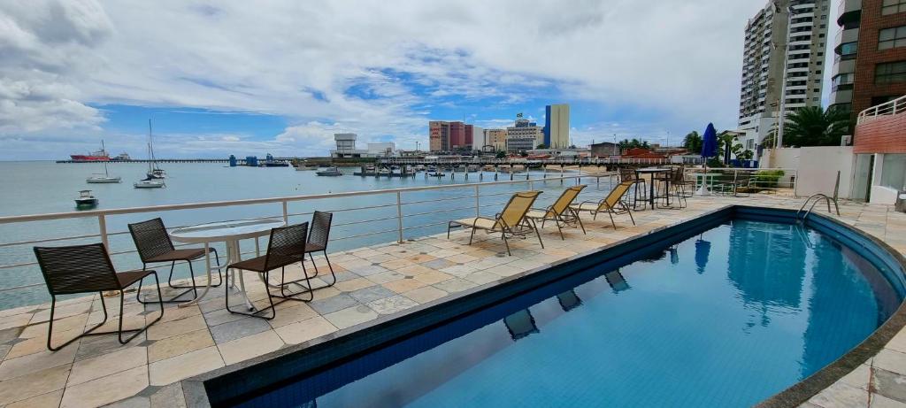 a swimming pool with chairs and a table on a balcony at Yacht Coast in Fortaleza