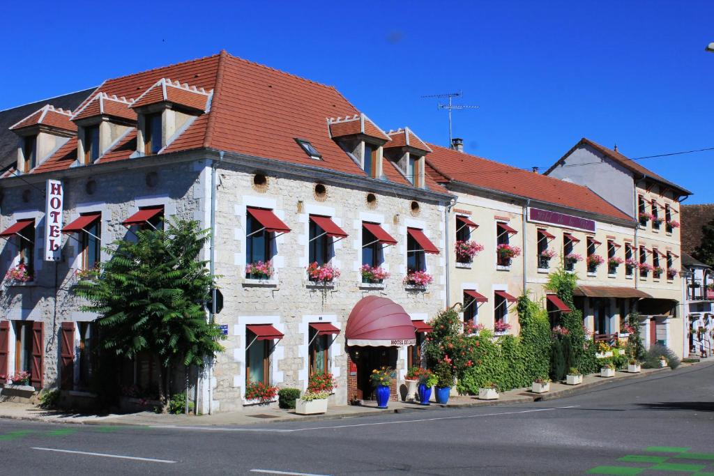 Hotel De La Loire في Saint-Satur: مبنى كبير مع مظلات حمراء على شارع