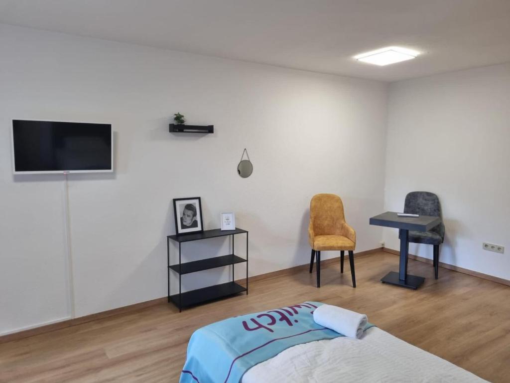 a bedroom with a bed and a desk and a tv at Twitch Appartments in Achim