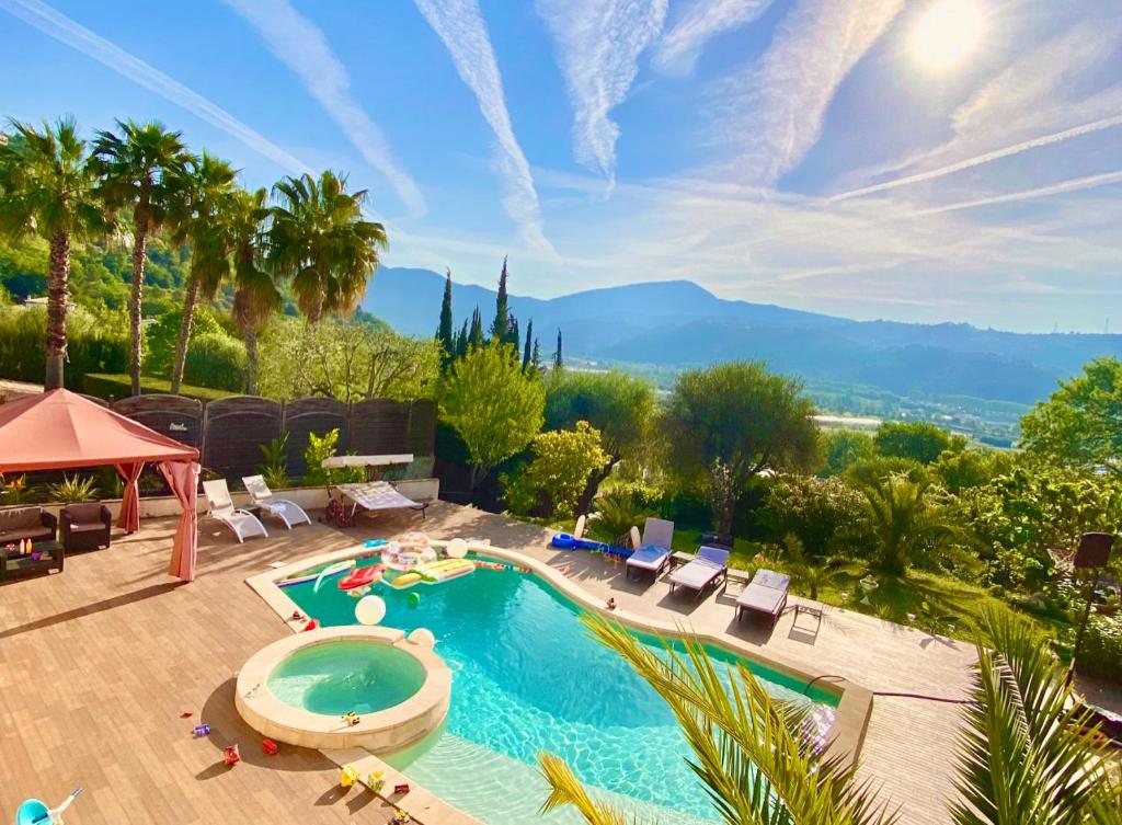 uma piscina exterior com cadeiras e uma piscina em Villa Canarias em Saint-Jeannet