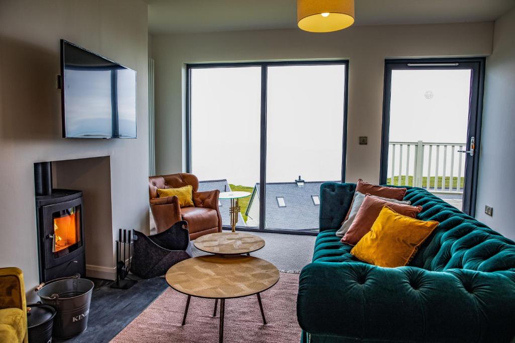 uma sala de estar com um sofá verde e uma lareira em 2 Bed Penthouse Apartment - 6 Plas em Pistyll