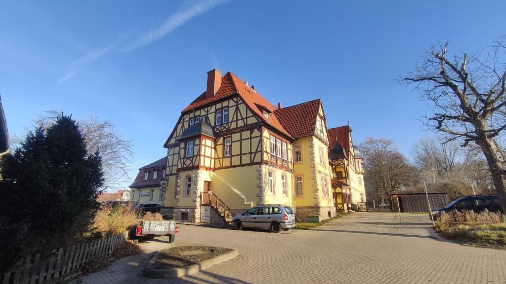 une grande maison avec une voiture garée devant elle dans l'établissement Gasthof "Zum Schloss", à Berßel