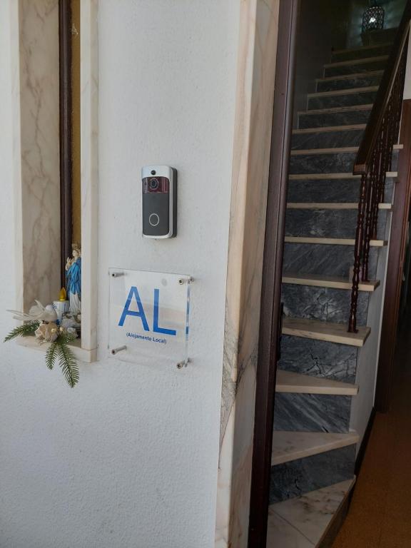 a stairwell with a sign on a wall next to a staircase at Quartos da Vóvó in Avis