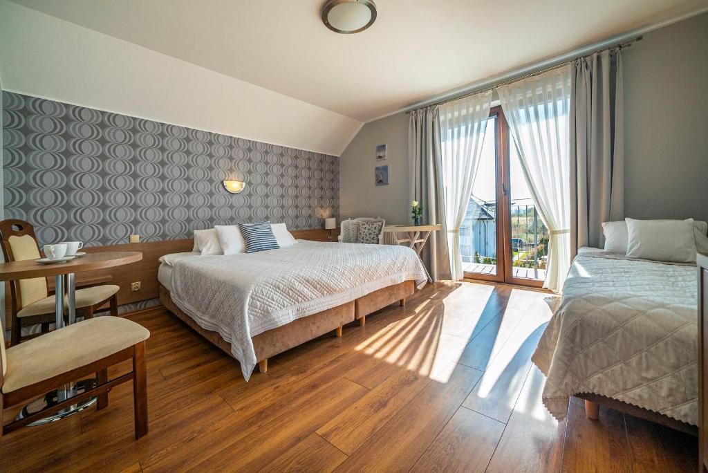 um quarto com 2 camas e uma grande janela em Pokoje gościnne Angela em Jastarnia