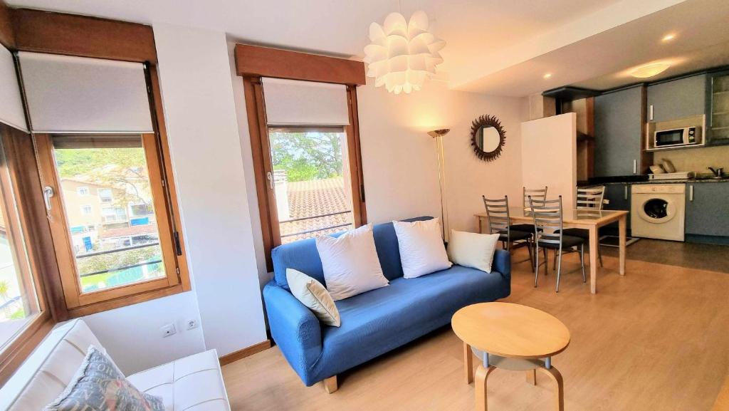 - un salon avec un canapé bleu et une table dans l'établissement Apartamento Vacacional Roma, à Barro de Llanes