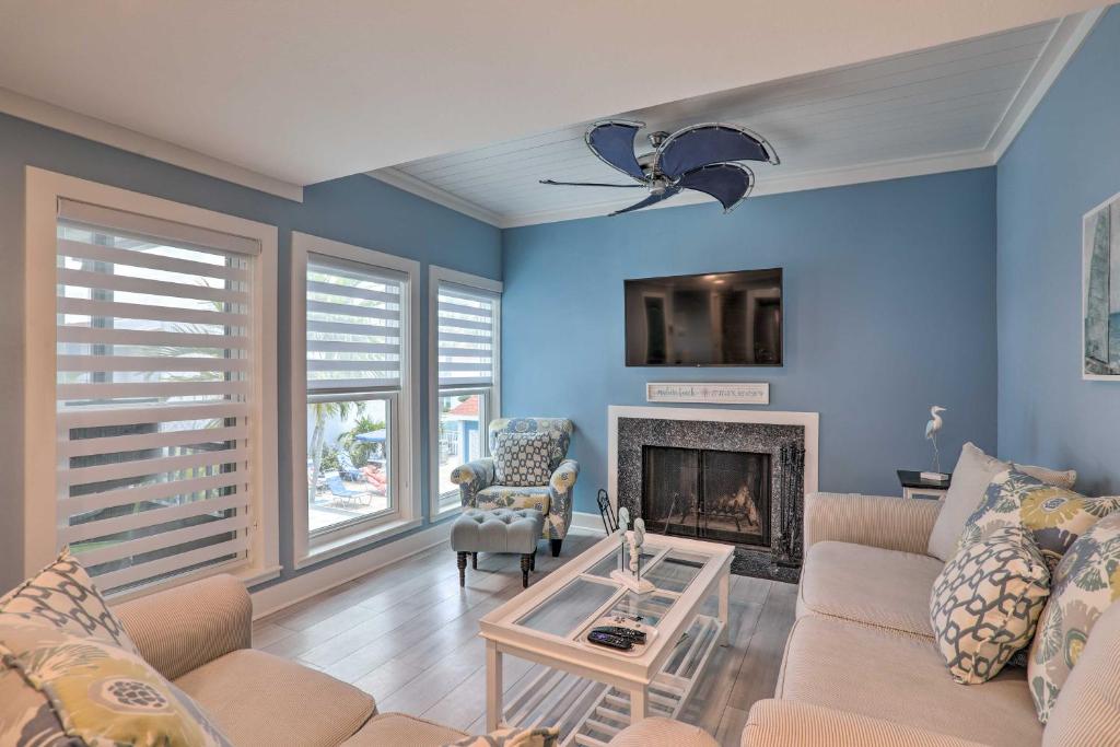 a living room with a couch and a fireplace at Poolside Madeira Beach Abode with Balcony! in St. Pete Beach