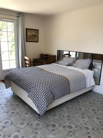 Schlafzimmer mit einem Bett mit einer schwarzen und weißen Bettdecke in der Unterkunft Nîmes calme in Nîmes