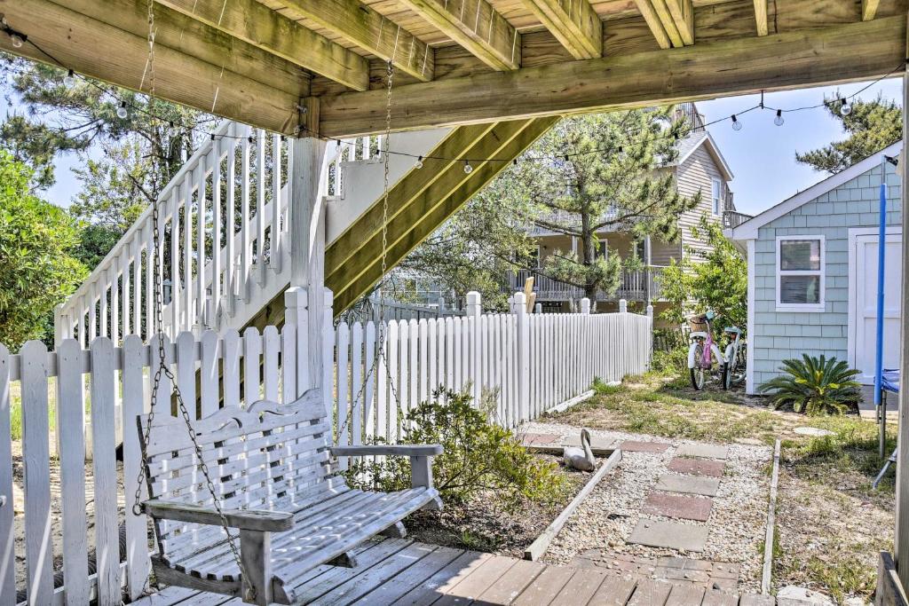 a swinging bench in front of a white fence at Dreamy, Coastal Studio Paradise with Hot Tub! in Nags Head