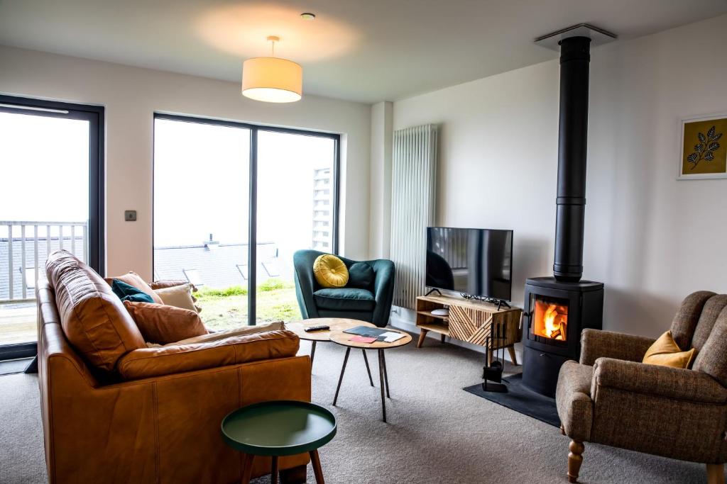 a living room with a couch and a fireplace at 2 Bed Ground Floor Apartment - 7 Plas in Pistyll