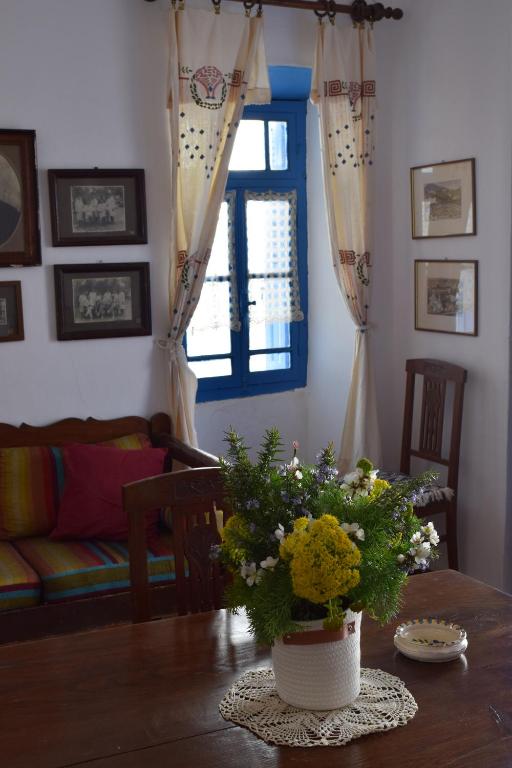 una sala de estar con una mesa con un jarrón de flores en Το πάνω σπίτι της Μαριάνθης, en Márpissa