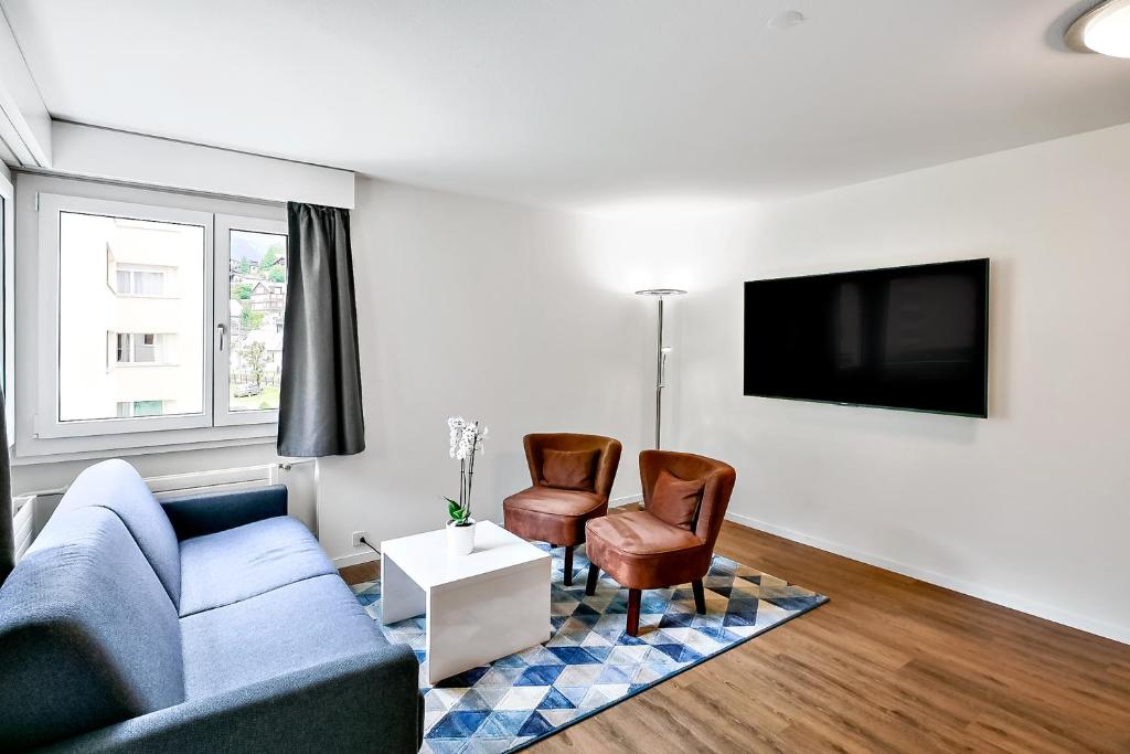 a living room with a couch and two chairs at Apartment nearby Titlis Station in Engelberg