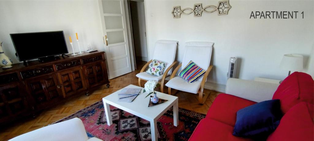 リスボンにあるCharming Family Apartmentのリビングルーム(赤いソファ、椅子2脚付)
