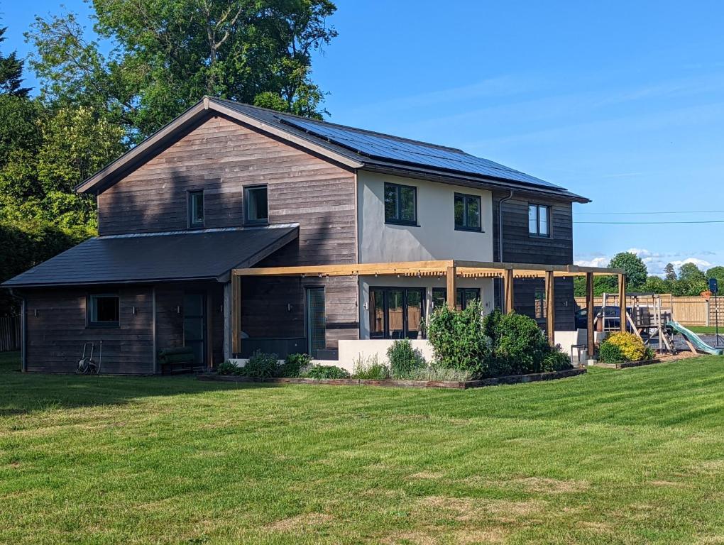 una casa con techo de gambrel en la parte superior de un patio en Unique, Spacious, Self-Built Eco Home with huge garden and movie room, en Andover