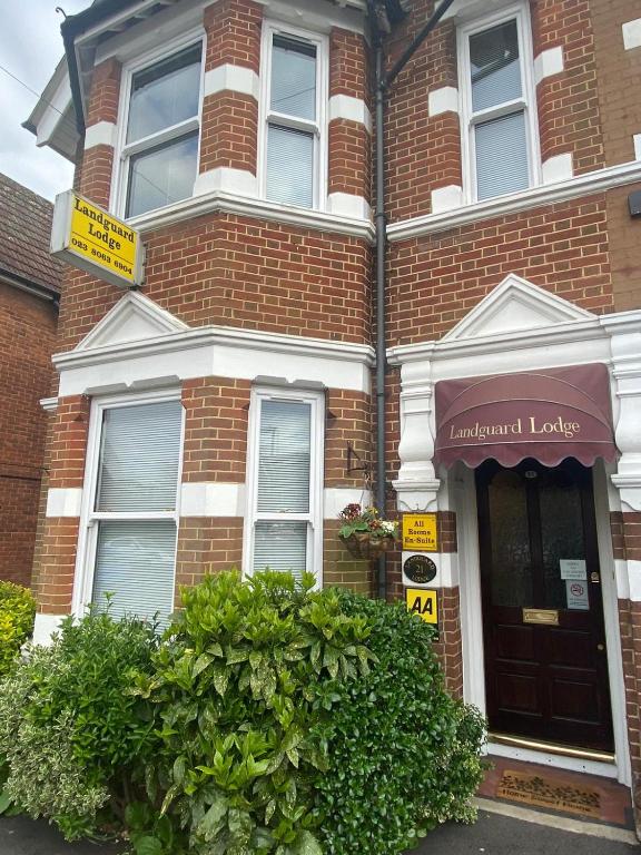 a brick house with a sign in front of it at Landguard Lodge Guest House in Southampton