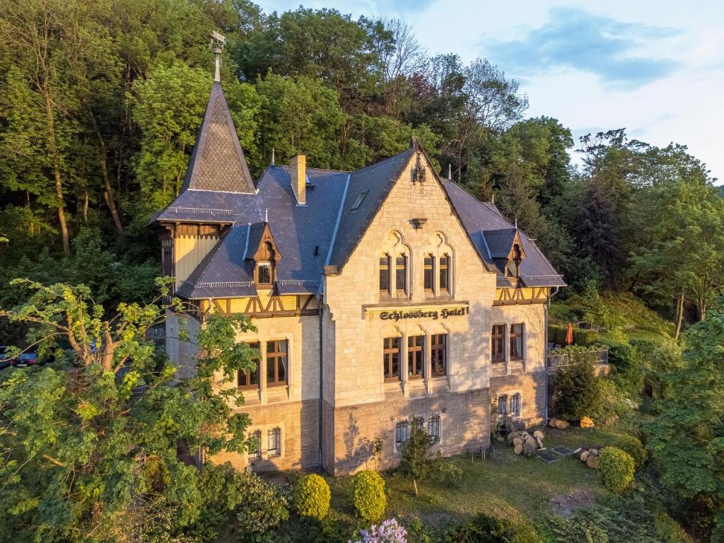 uma casa velha numa colina com árvores em Schlossberg-Hotel Garni em Wernigerode