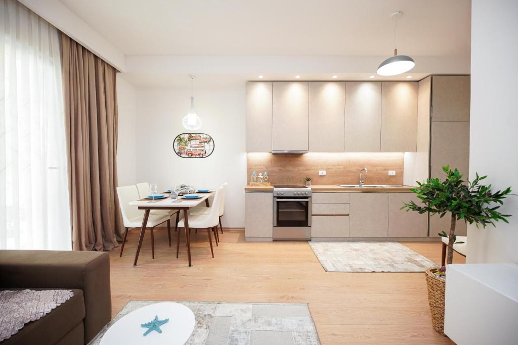 cocina y sala de estar con mesa y sillas en ROGA Apartment Valamar, en Hamallë