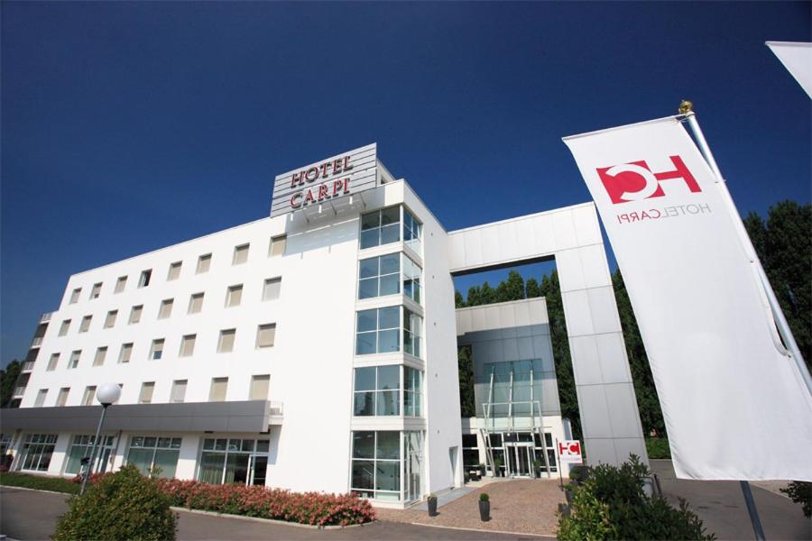 a large white building with a dr sign in front of it at Hotel Carpi in Carpi