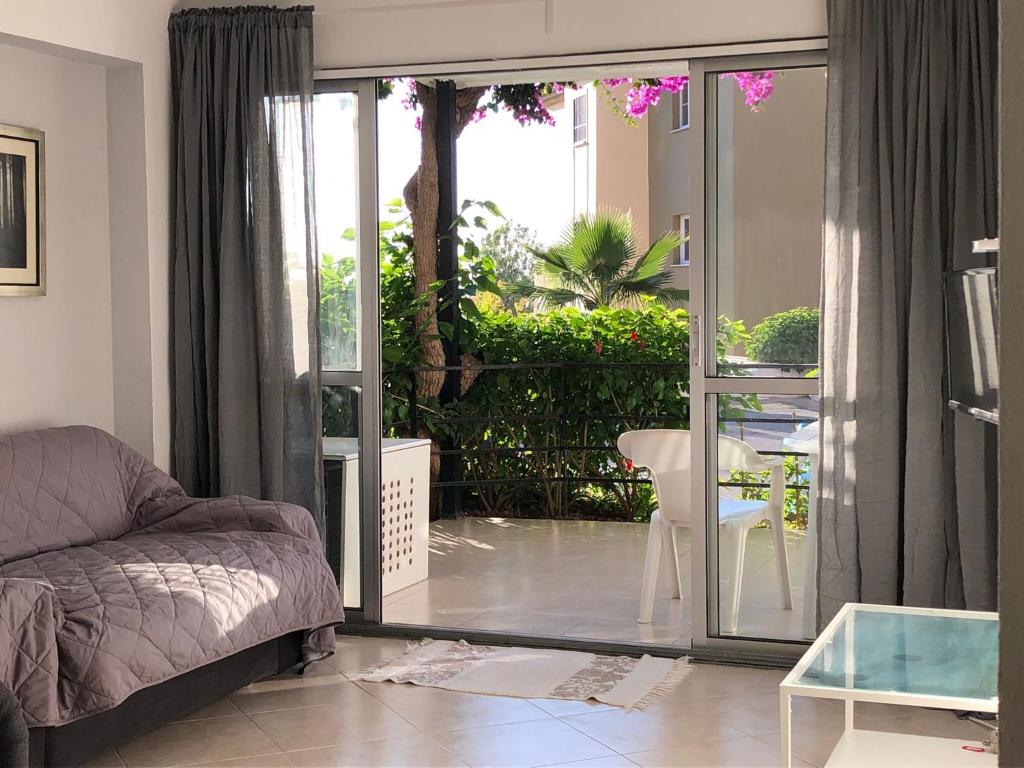 - un salon avec un canapé et une porte coulissante en verre dans l'établissement NEW Tranquilo apartamento a un paso de la playa y del centro, à Torremolinos