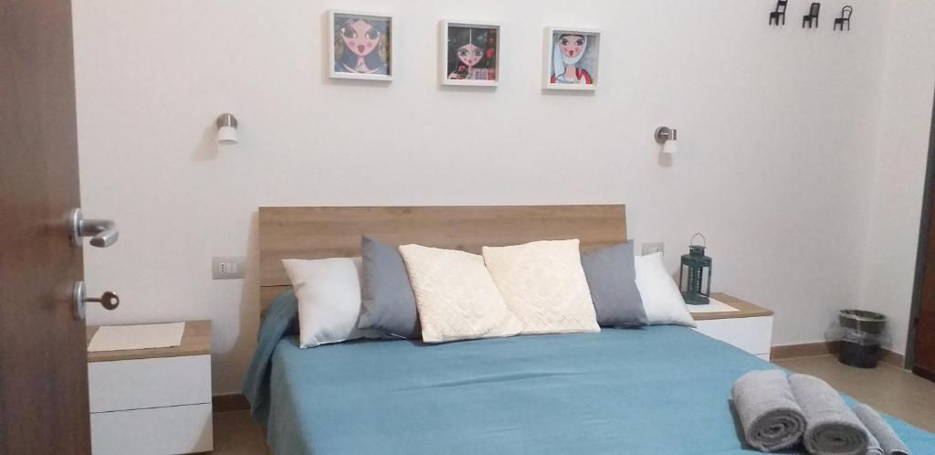 カポテッラにあるIl Vecchio Gineproのベッドルーム1室(壁に3枚の写真が飾られた青いベッド1台付)