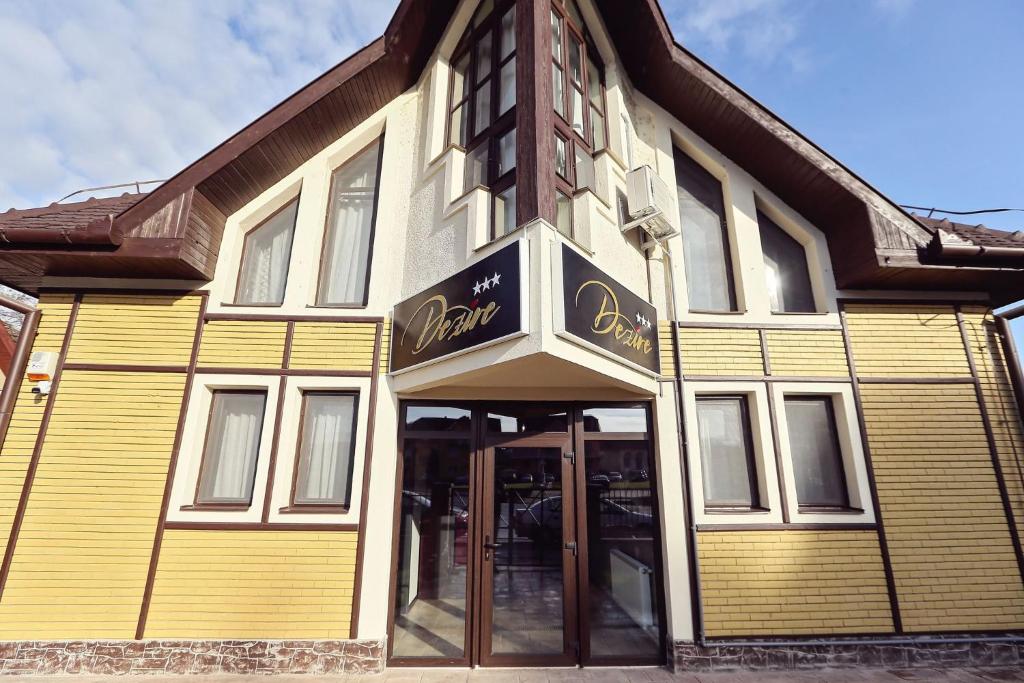 un edificio amarillo con un cartel en la parte delantera en Dezire Guesthouse, en Baile 1 Mai