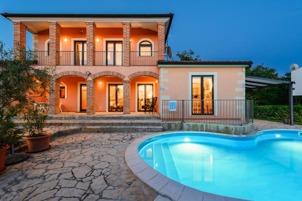 a house with a swimming pool in front of it at Villa Imagine in Višnjan