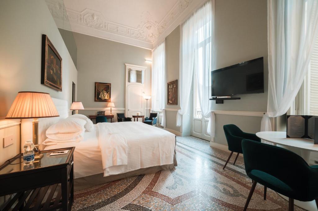a hotel room with two beds and a television at Royal Palace Hotel in Turin