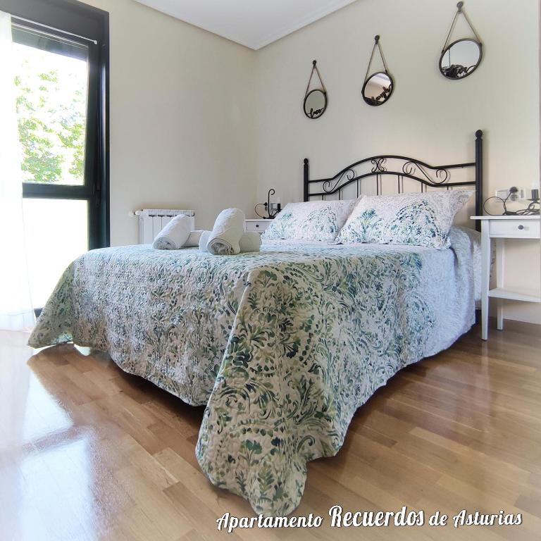 a bedroom with a bed with a blue and green bedspread at RECUERDOS DE ASTURIAS in Piedras Blancas