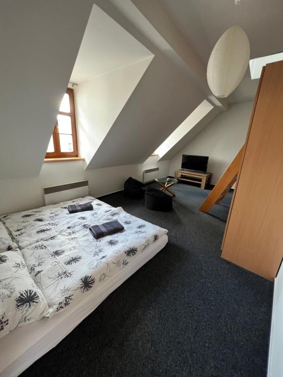 - une chambre mansardée avec un grand lit dans l'établissement Apartmány U Vodního hradu, à Česká Lípa