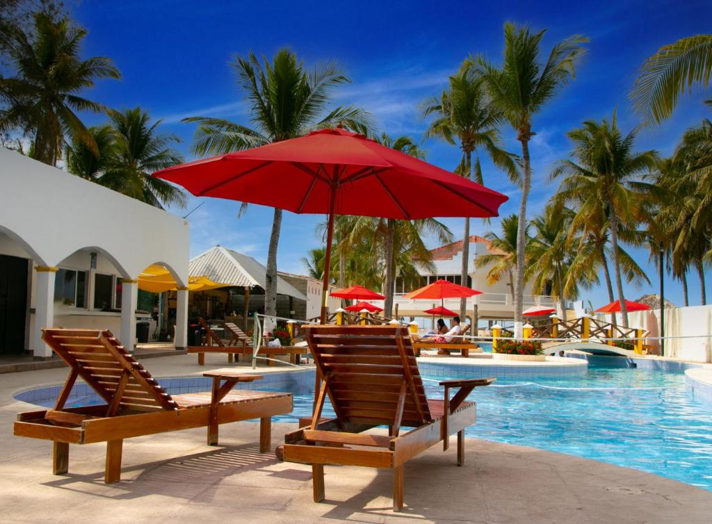 - une piscine avec 2 chaises et un parasol rouge dans l'établissement Hotel Bahia del Sol, à La Herradura