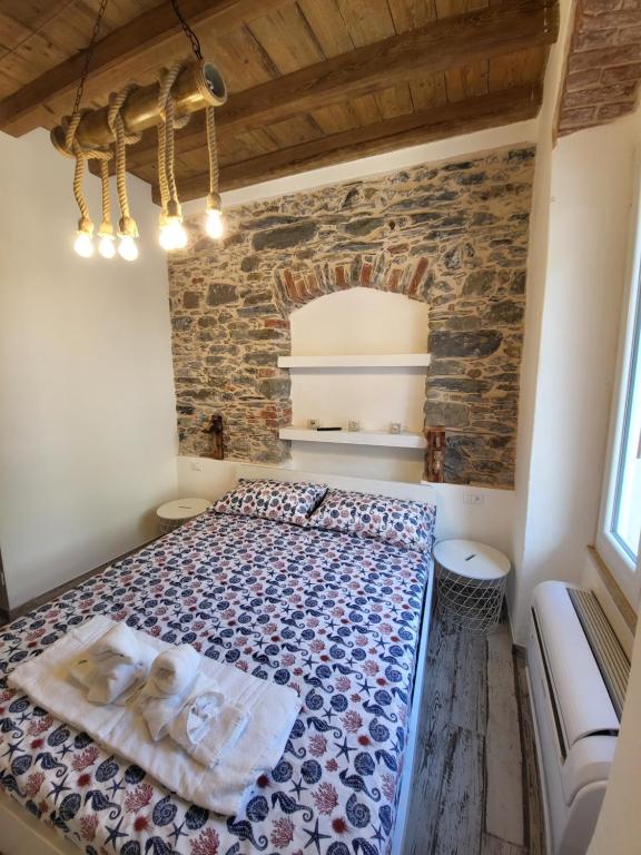 1 dormitorio con 1 cama en una habitación con una pared de ladrillo en L' Onda di Manarola, en Manarola