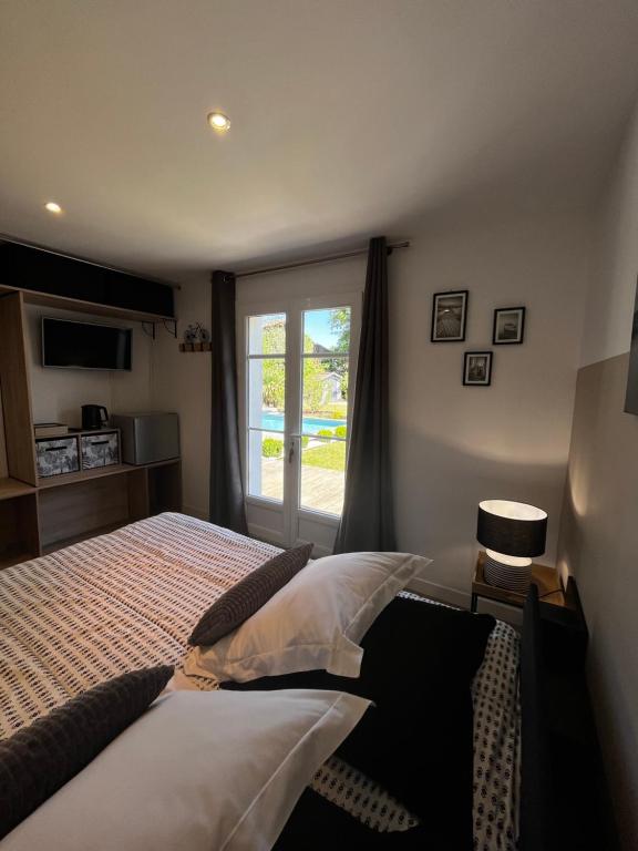1 dormitorio con cama y ventana en Chambre avec salle de bain privée de la Canopée de Mios, en Mios