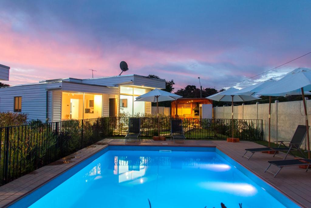 a swimming pool in front of a house at Cabañas Rio Rapel in Rapel