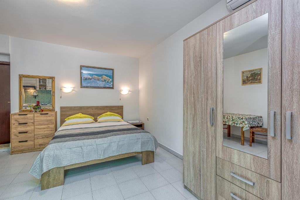 1 dormitorio con 1 cama y armario de madera en Apartments Baštovanović, en Rovinj