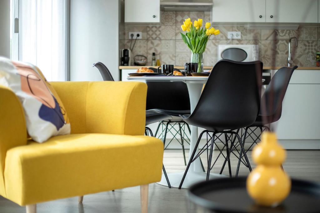 a kitchen with a yellow chair and a table at TREND BA HOME Apartman in Balatonalmádi