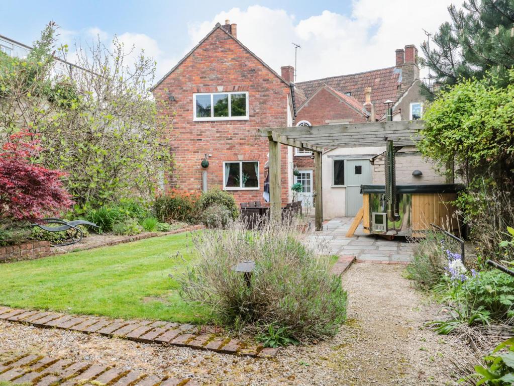 a brick house with a gate and a yard at Holloway House in Wotton-under-Edge