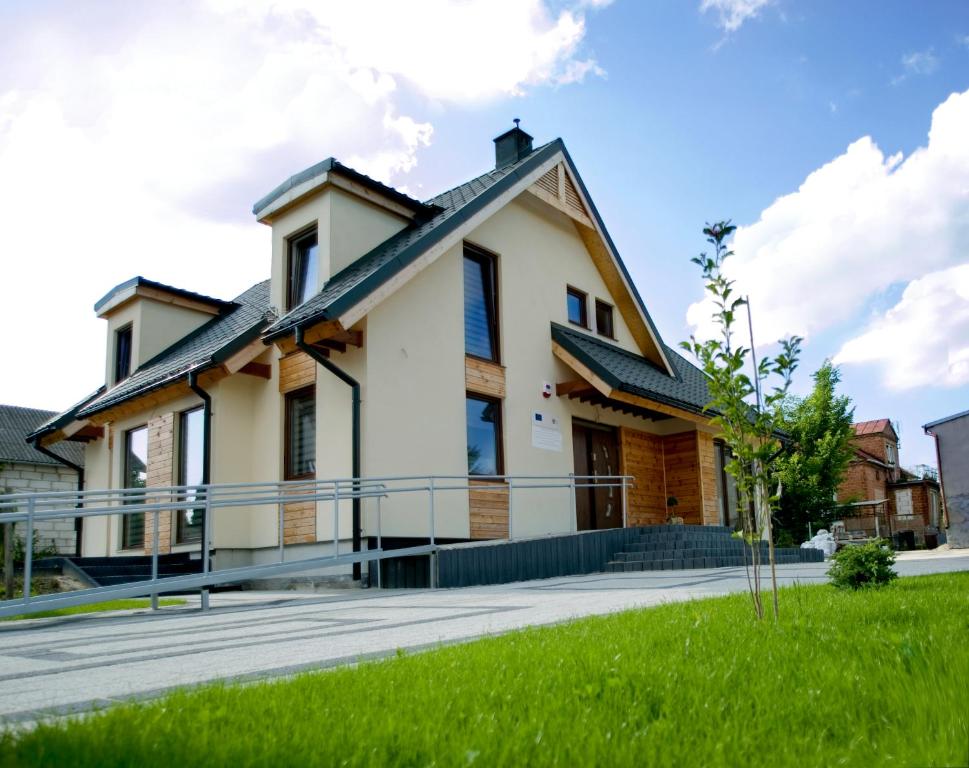 ザモシチにあるVilla Comfortの玄関と緑の芝生のある家