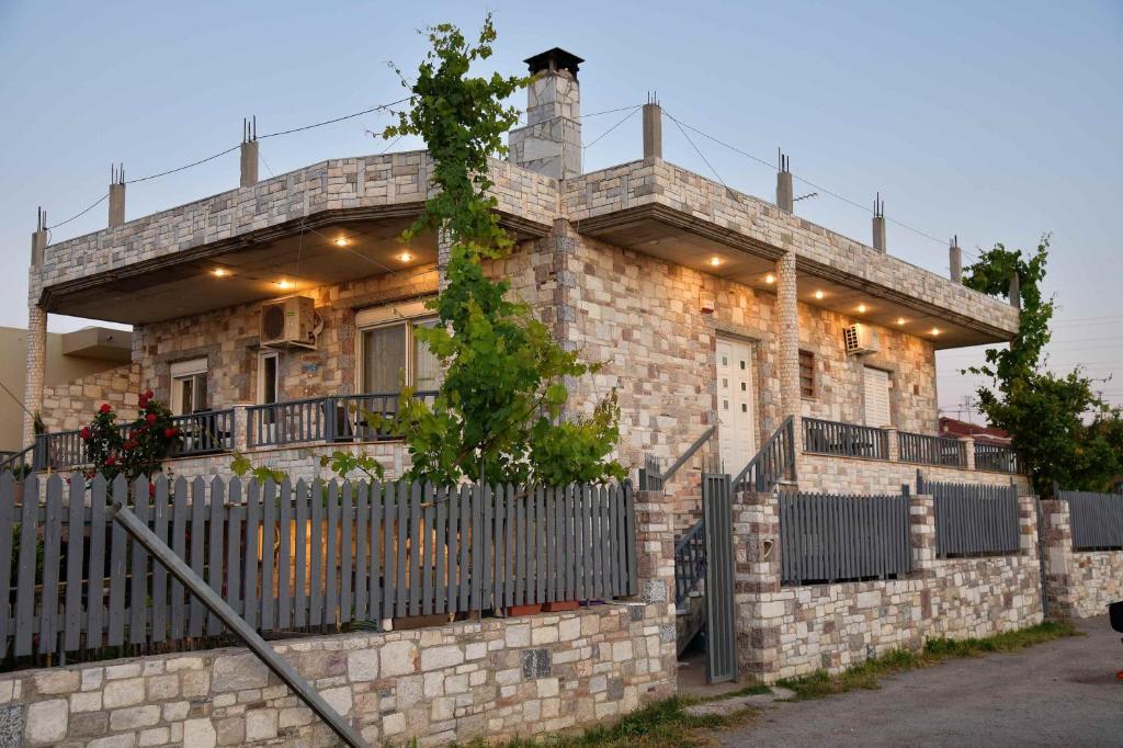 a brick house with a fence in front of it at Stone Villa in Korinthos