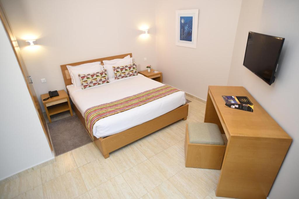 Dormitorio pequeño con cama y mesa en Downtown Tunis Hotel en Túnez