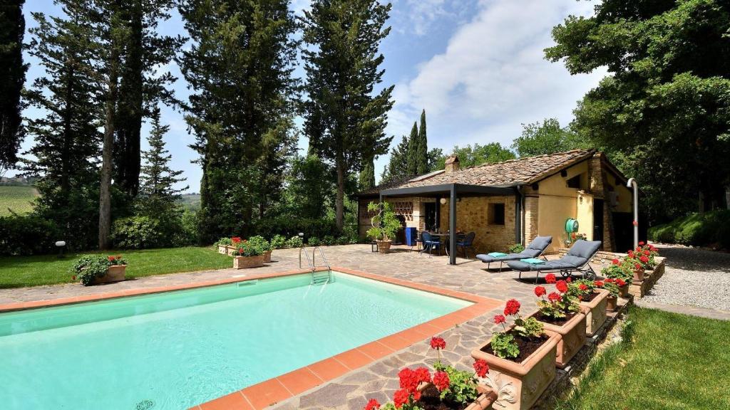 a swimming pool in a yard next to a house at La Fornace in San Casciano in Val di Pesa