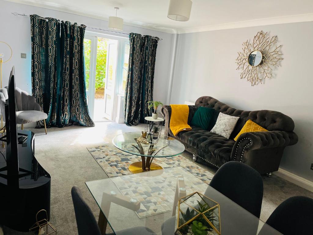 a living room with a couch and a glass table at Esplanade lodge in Strood