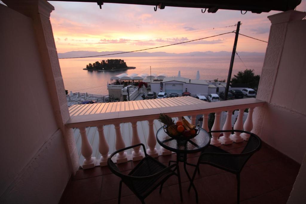a balcony with a table and a view of the water at Batis Breeze in Perama