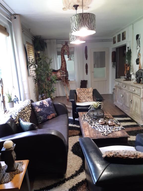 uma sala de estar com sofás e uma mesa em B&B de Vrijheid en de Ruimte in Steenbergen em Steenbergen