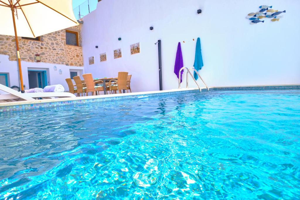 a swimming pool with an umbrella and a table and chairs at C'AN ANGELA in Artá