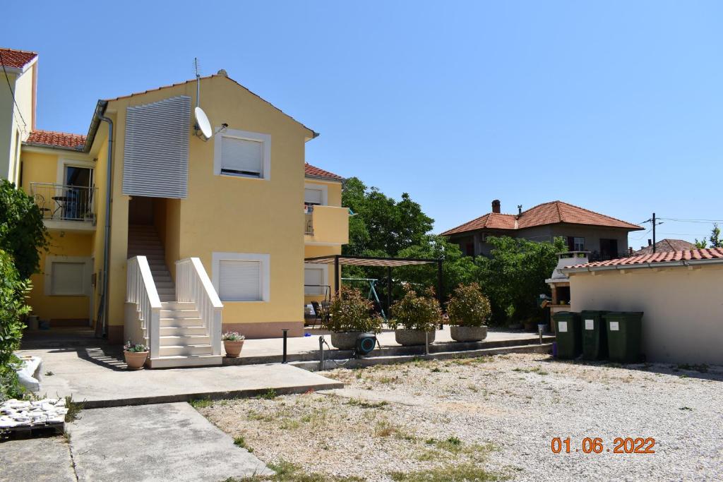 ein gelbes Haus mit Pflanzen im Hof in der Unterkunft Sea Horse in Zadar